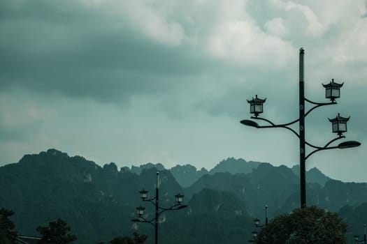 Lampposts on the street in Wulingyuan with the stunningly beautiful rocky karst mountain formations in the background, Hunan Province, China