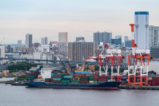 Big Cargo Containers Boat with Goods cargo Stack at the Pier docks port waiting for international sea freight transportation import and export in Tokyo bay Port of Tokyo Japan