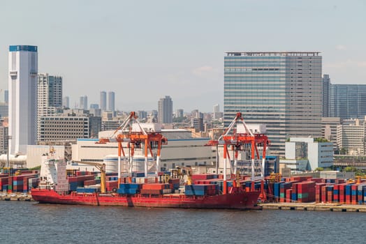 Big Cargo Containers Boat with Goods cargo Stack at the Pier docks port waiting for international sea freight transportation import and export in Tokyo bay Port of Tokyo Japan