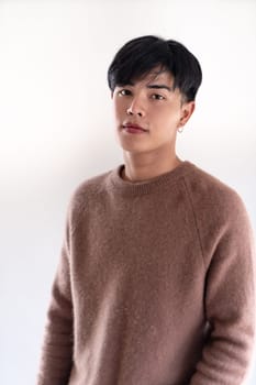 Portrait of good-looking smart Teenager young asian adult boy wearing brown sweater for winter on white background