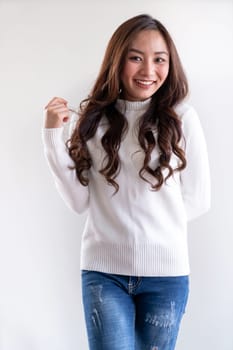 Portrait of good-looking beautiful young asian adult girl wearing white sweater for winter pointing to blank copy space on white background