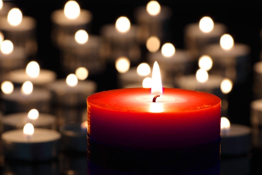 A red candle on christmas night signifying hope. Gold. Background. Selective focus.