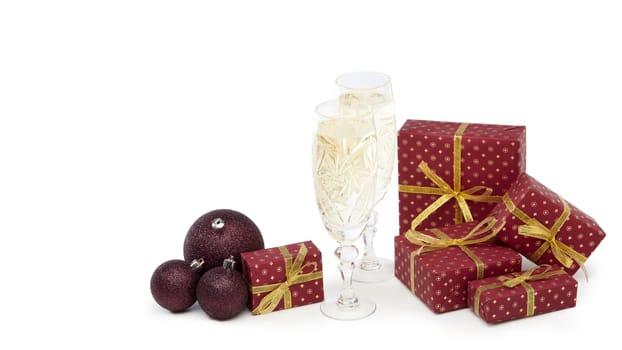Still life with two champagne flutes, gift boxes and Christmas decoration isolated on white background with copy space. Christmas and New Year shopping. Greeting card