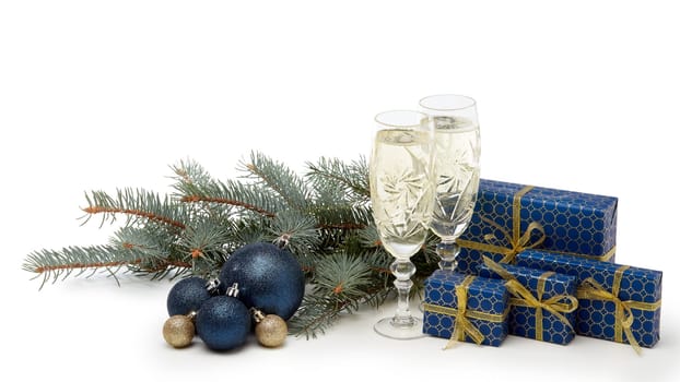 Still life with two champagne flutes, gift boxes and Christmas decoration with fir tree branch isolated on white background with copy space. Christmas and New Year shopping. Greeting card