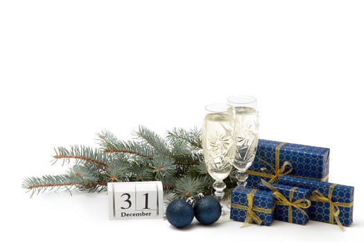 Still life with two champagne flutes, gift boxes and decoration with fir tree branch isolated on white background with copy space. New Year shopping. Greeting card