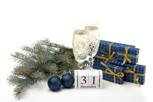 Still life with two champagne flutes, gift boxes and decoration with fir tree branch isolated on white background with copy space. New Year shopping. Greeting card