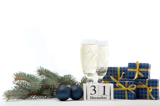 Still life with two champagne flutes, gift boxes and decoration with fir tree branch isolated on white background with copy space. New Year shopping. Greeting card