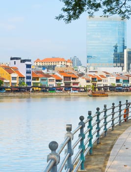 Colorful buildings of Boat Quay district and modern buildings facades view from Singapore embankment
