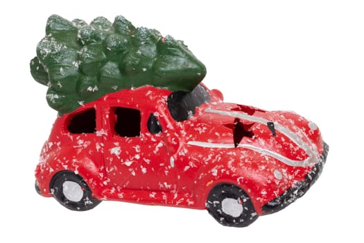 Christmas decorations background. Closeup of a snow-covered red car toy with green fir-tree on the roof isolated on a white background. Saisonal design element for cards or stickers. Macro.