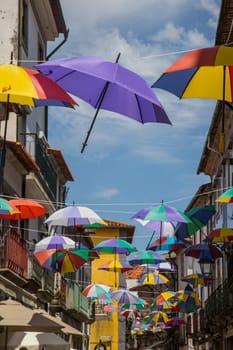 Eine Gasse mit bunten Schirmen in Viana do Castelo in Portugal