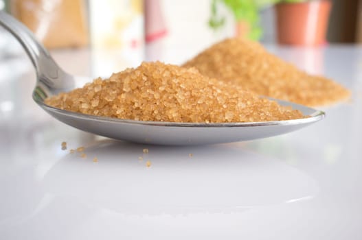 Spoon and heap of brown sugar. Close-up