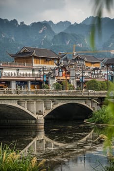 Wulingyuan, China - August 2019 : Wide arched bridge over Suoxiyu river in the ancient part of Wullingyuan town, Hunan Province