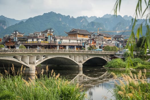 Wulingyuan, China - August 2019 : Wide arched bridge over Suoxiyu river in the ancient part of Wullingyuan town, Hunan Province