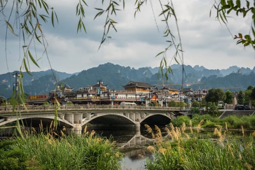 Wulingyuan, China - August 2019 : Wide arched bridge over Suoxiyu river in the ancient part of Wullingyuan town, Hunan Province