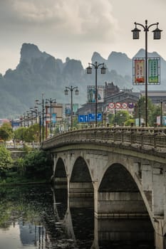 Wulingyuan, China - August 2019 : Wide arched bridge over Suoxiyu river in the ancient part of Wullingyuan town, Hunan Province