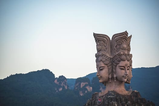Wulingyuan, China -  August 2019 : Four faced sculpture at the entrance to the Romance Park located in Suoxiyu Town in Wulingyuan.  It is famous for the show of Zhangjiajie Romance performance.