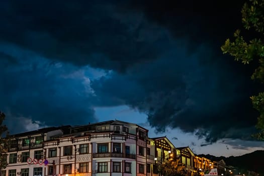 Wulingyuan, China - August 2019 : Residential buildings lit at night at a busy high street in Wulingyuan town at dusk