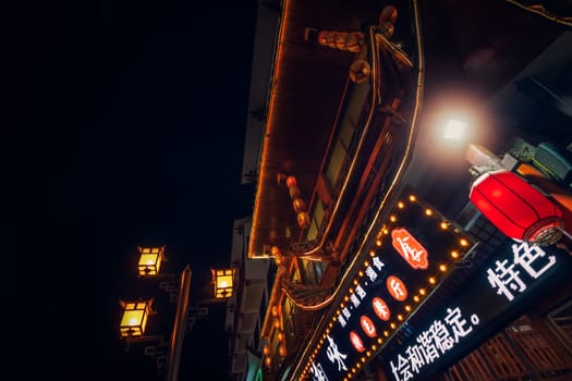 Wulingyuan, China - August 2019 : Advertising neon over chinese restaurant in bustling part of Wulingyuan town, Hunan Province