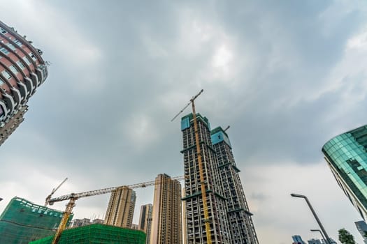 Chengdu, China -  July 2019 : Cranes on the building site of brand new high rise living apartments in the centre of town, Sichuan Province