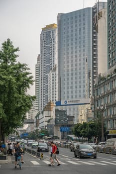 Chengdu, China -  July 2019 : People crossing the busy street in the commercial part of the city of Chengdu in summer, Sichuan Province
