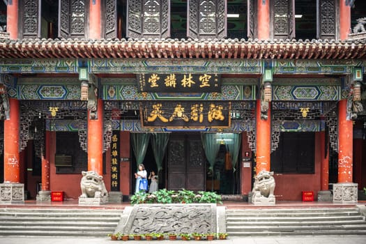Chengdu, China -  July 2019 : People going through the door entrance of the impressive temple in Wenshu Monastery
