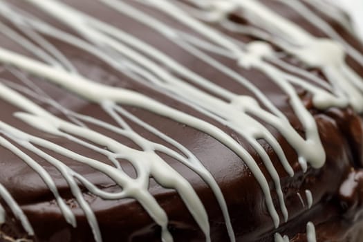 Homemade chocolate cake with chocolate glaze with white stripes on brown