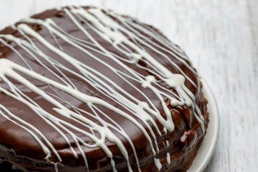 Homemade chocolate cake with chocolate glaze with white stripes on brown