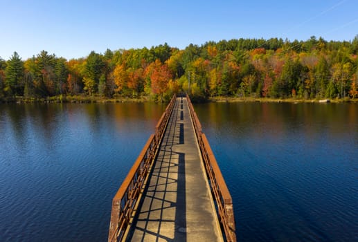 Fall color has begun to appear in the trees around a like in the Adirondacks