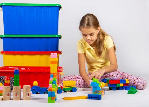 Ten year old girl playing toys sitting on the floor