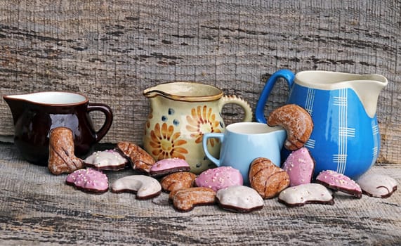 Colourful gingerbread and old coffee pots on a wooden background