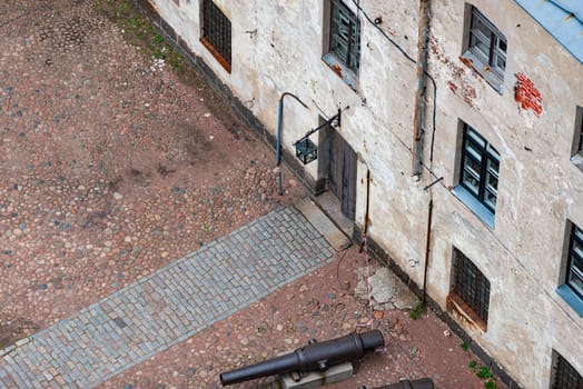 Courtyard of Vyborg castle in Russia. Old street with pathway and cobblestone floor.