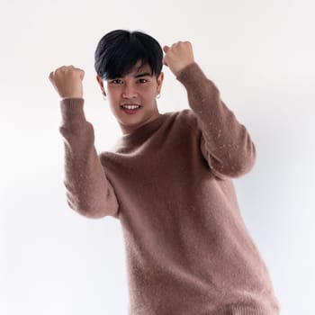 Portrait of good-looking smart Teenager young asian adult boy wearing brown sweater for winter on white background