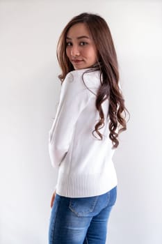 Portrait of good-looking beautiful young asian adult girl wearing white sweater for winter pointing to blank copy space on white background