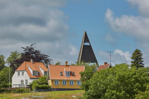 SVANEKE, DENMARK - JULY 4, 2017: View of village of Svaneke in Denmark and modern three-legged water tower designed by Jorn Utzonon.