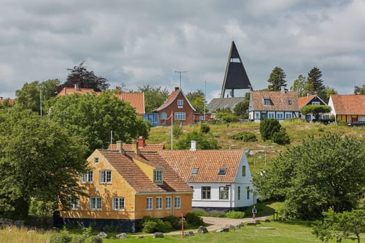 SVANEKE, DENMARK - JULY 4, 2017: View of village of Svaneke in Denmark and modern three-legged water tower designed by Jorn Utzonon.