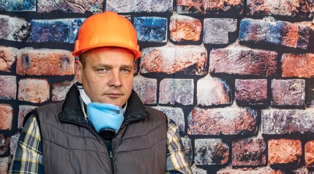 A man in a respirator against the background of the wall. Working. Profession.