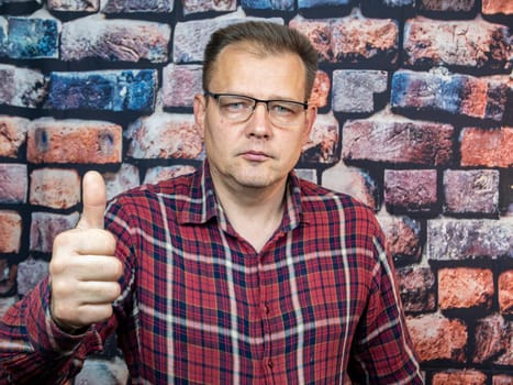 A man with glasses shows a good gesture. Symbols and gestures. Ok.