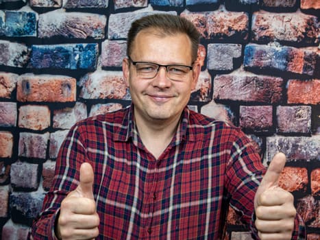 A man with glasses shows a good gesture. Symbols and gestures. Ok.