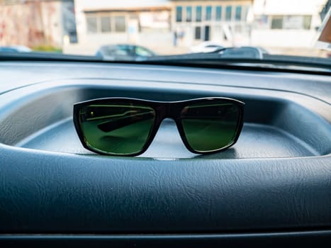 Sunglasses on a dashboard of a car. Place for text. Transport.