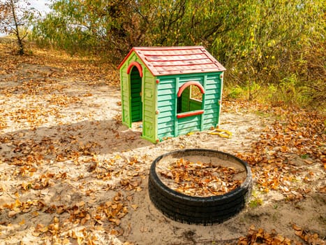 Children's playground with a house on the sand. Children's games.