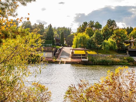 Autumn river landscape against a cloudy sky. Autumn foliage. Water. Background image. River bank.