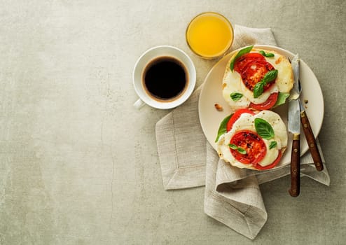 Breakfast served with mozzarella sandwich, juice and coffee on the table top view. Healthy breakfast food.