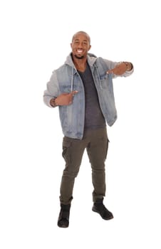 A handsome African American man standing in a jeans jacket, smiling.and pointing with his fingers at himself, isolated for white background.