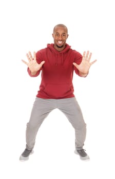 A tall handsome African American man standing in the studio with his.hands up, saying NO, I don't wont this, isolated for white background.