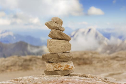 Stones stack in mountain panorama with blue sky visualizes creativity, consulting, success or showing health, meditation and therapy.