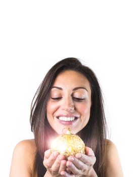 Dreamy woman holding a shiny golden Christmas ball isolated on a white background. Christmas and Happy New Year celebration holiday party concept. Mock up copy space.