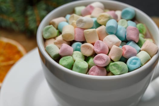 Marshmello with cocoa in a mug on a surface of different colors