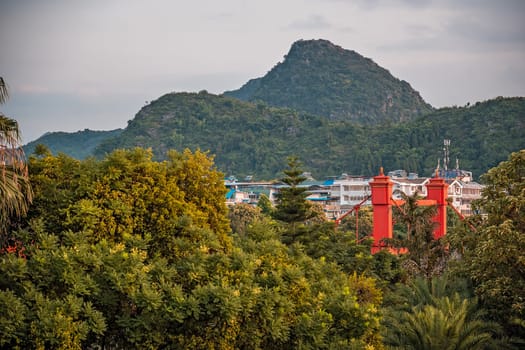 Red bridge on Sanduo Lu street in Guilin town city with karst mountains in the background, Guangxi Province, China