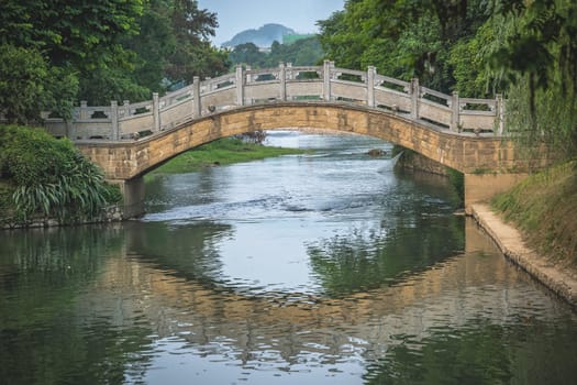 Small arched old bridge on Li River in Elephant Trunk Hill park in Guilin town, Guangxi Province, China