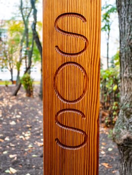Sos is written on a wooden post. Help.